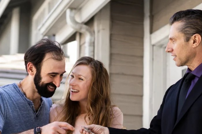 First-time home buyers receiving the keys to their first home from their agent