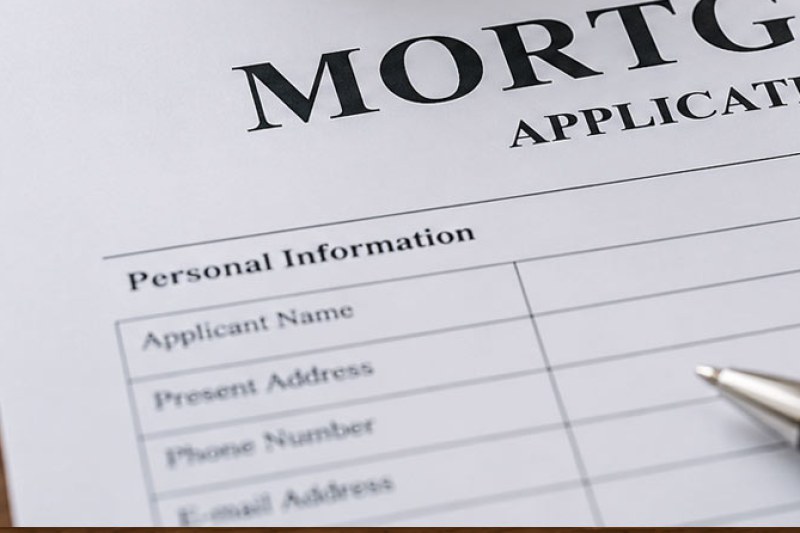 A mortgage application form showing the personal information section, with a pen resting beside it